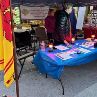 People standing behind a table displaying merchandise