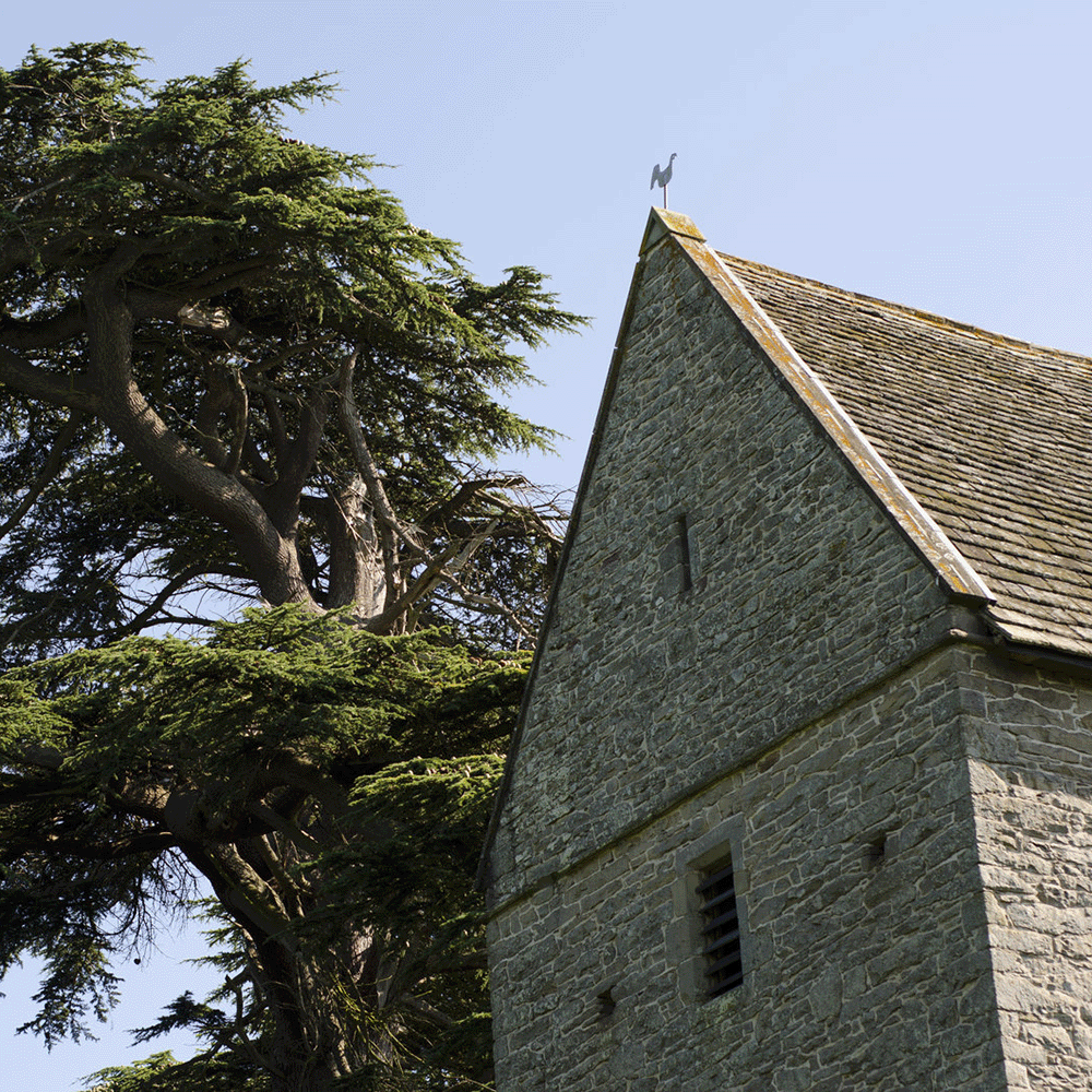 A stone church next to a tree 